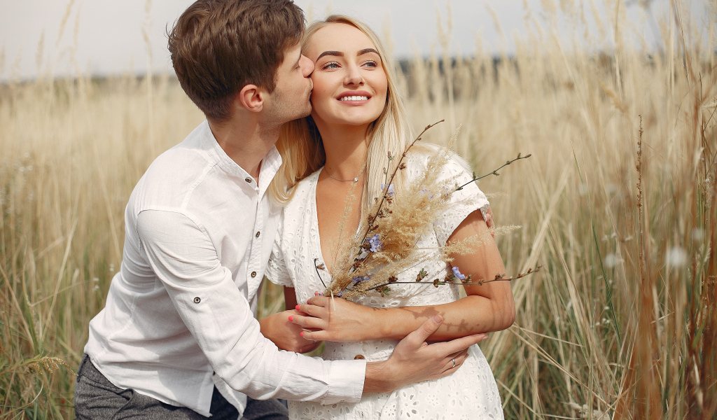 Поцелуй красивой пары на поле