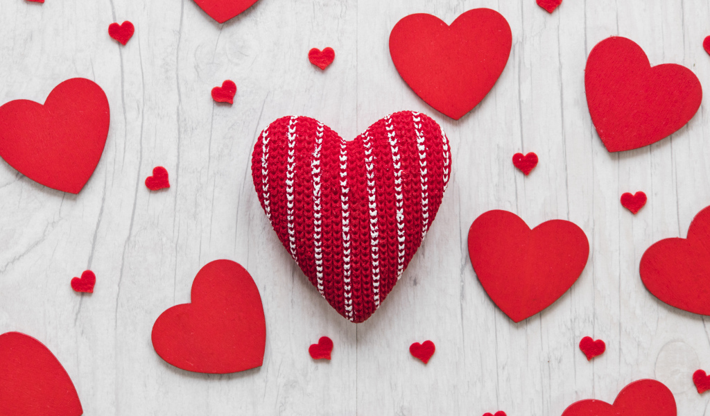 Много красных сердец на белом деревянном столе