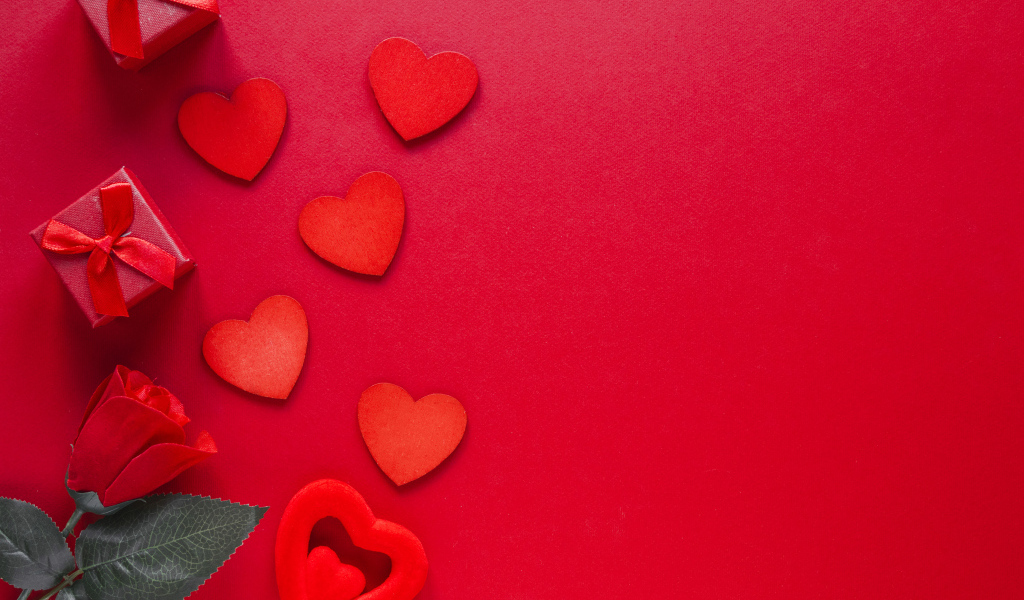 Бумажные сердечки с подарком и розой на красном фоне