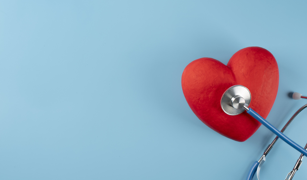 Красное сердце слушают стетоскопом