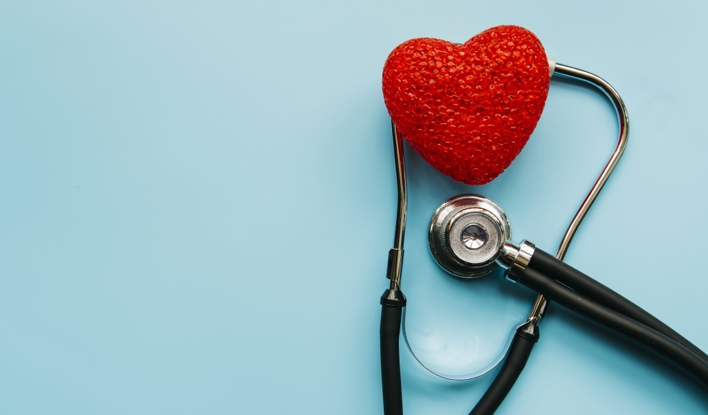 Красное сердце с стетоскопом на голубом фоне