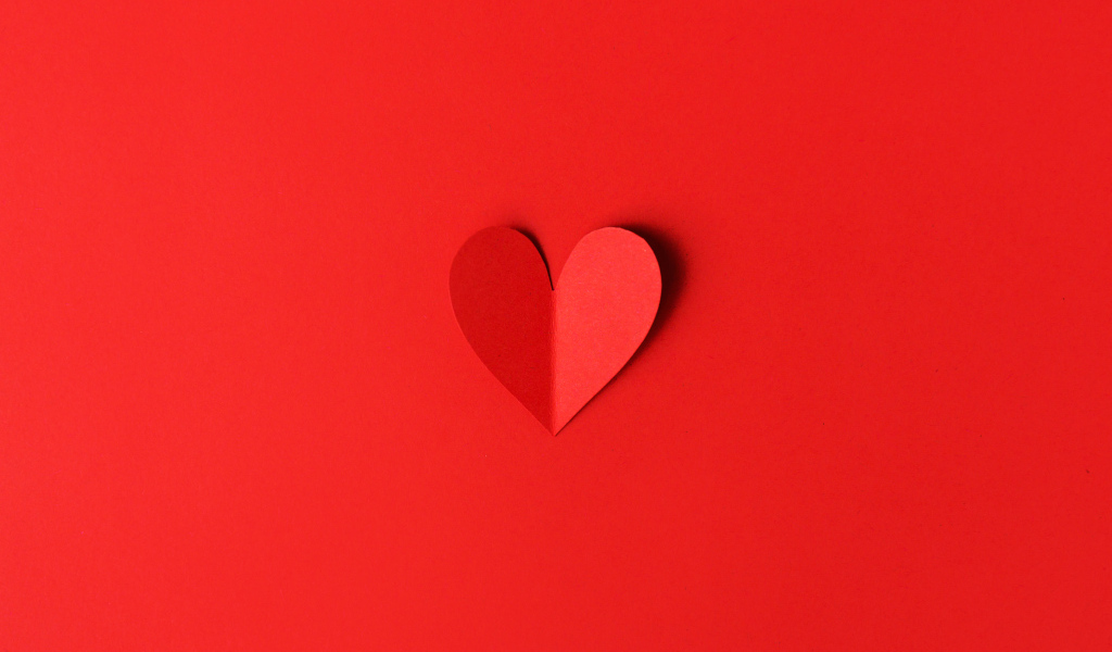 Маленькое бумажное сердце на красном фоне
