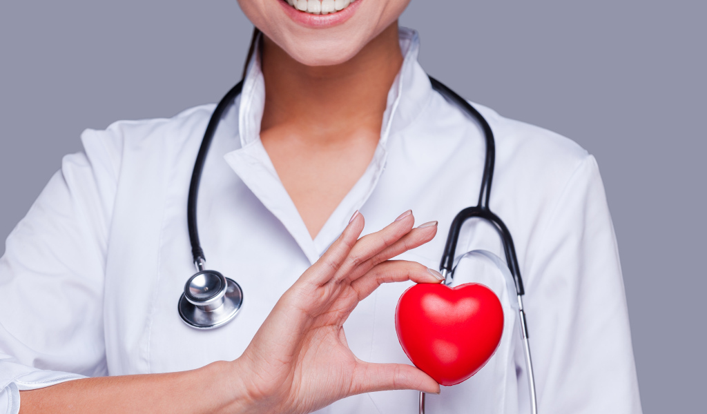 Улыбающаяся женщина врач с красным сердцем