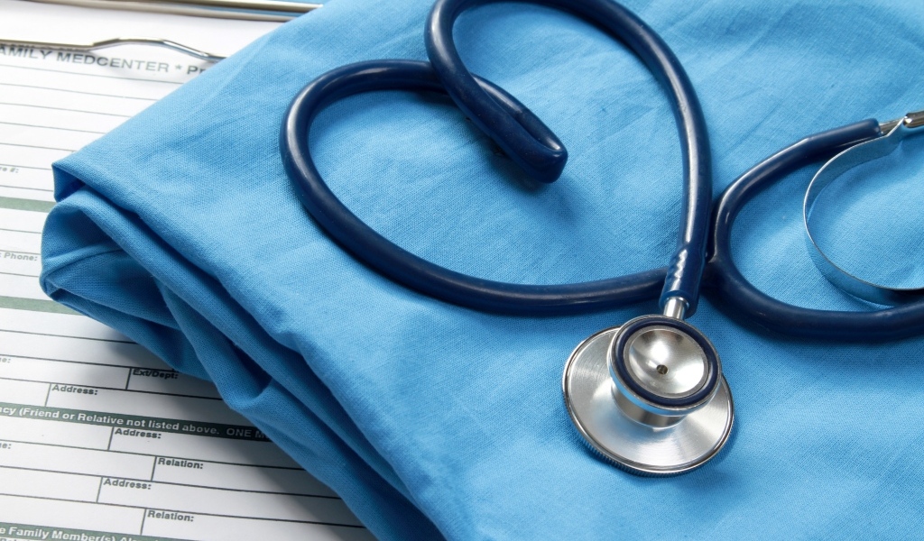 Стетоскоп с медицинским халатом на столе