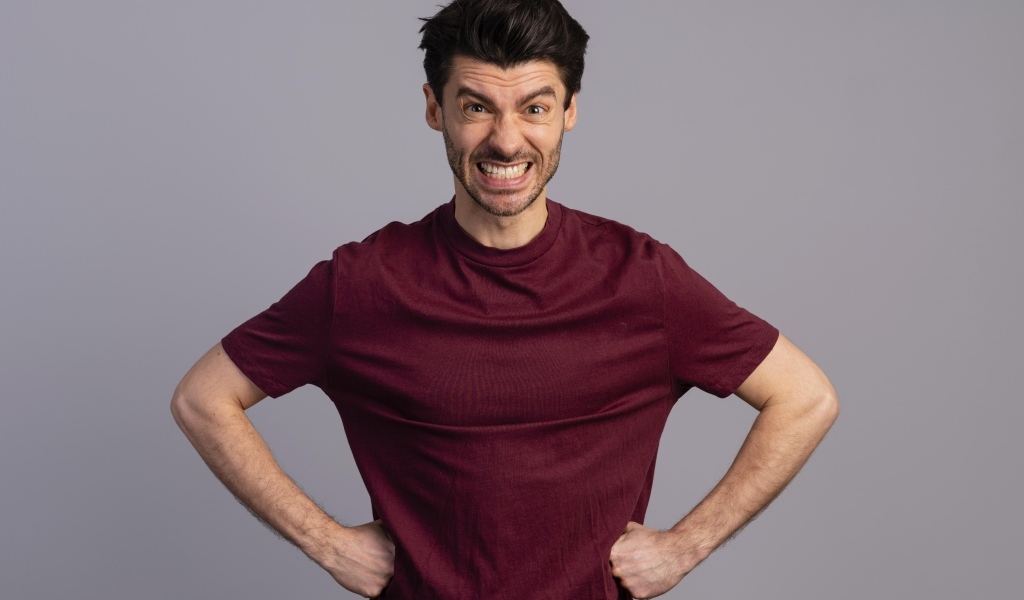 Злой мужчина на сером фоне