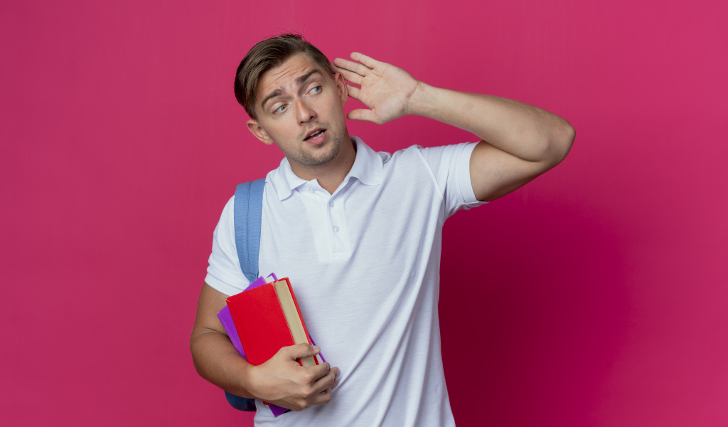 Парень с книгами в руке на красном фоне