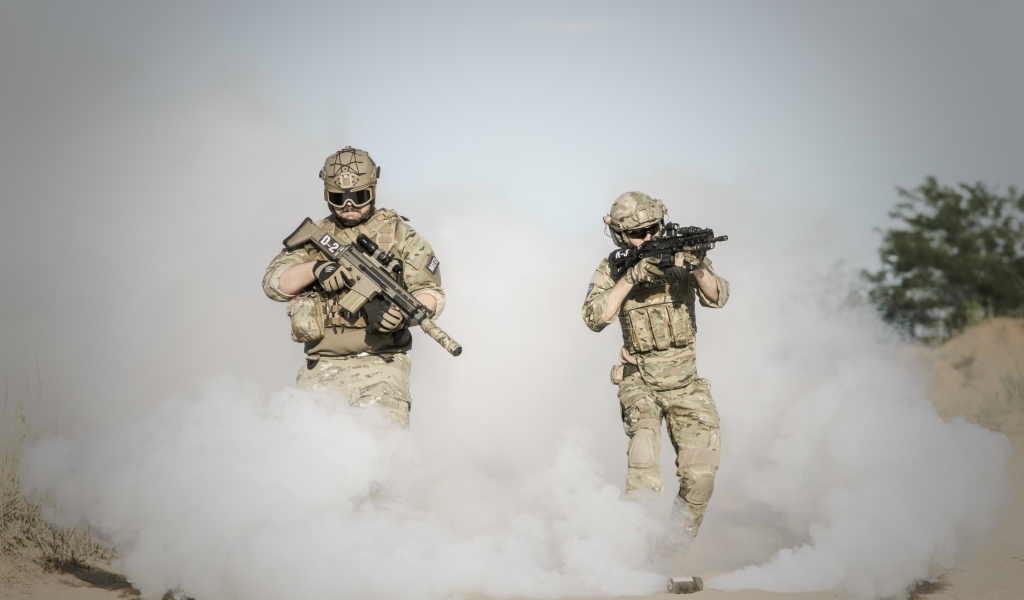 Мужчины солдаты с оружием в дыму