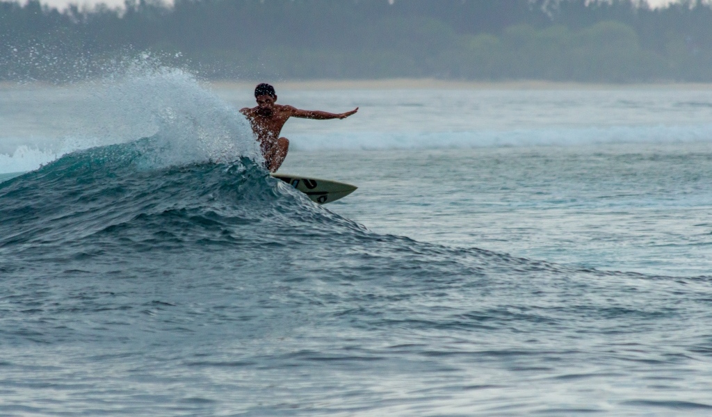 Мужчина серфингист ловит волну