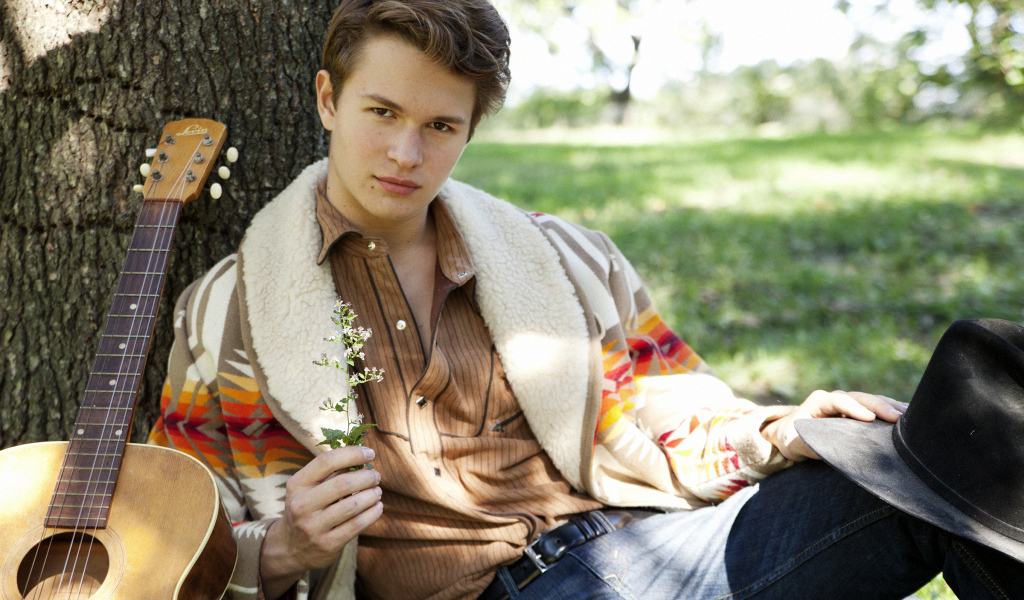 Актер Энсел Эльгорт с гитарой у дерева