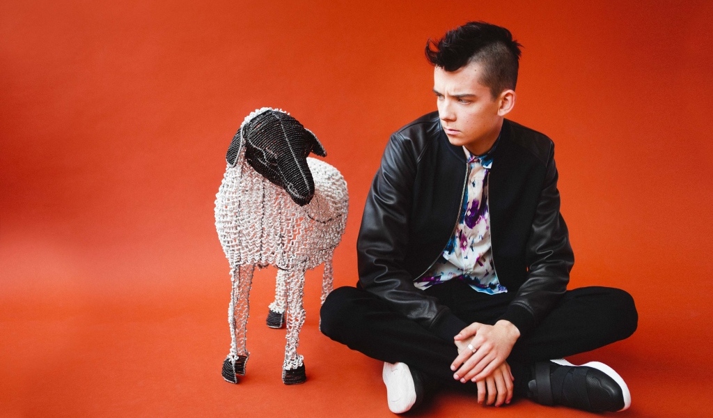 Молодой актер Эйса Баттерфилд на красном фоне