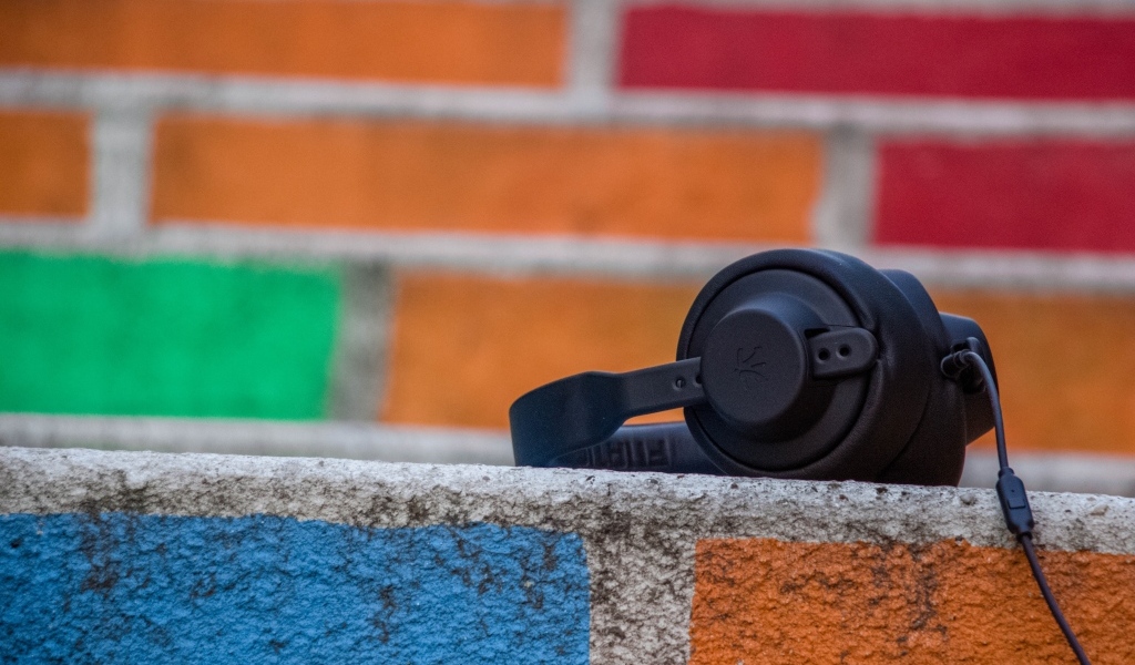 Черные наушники лежат на стене