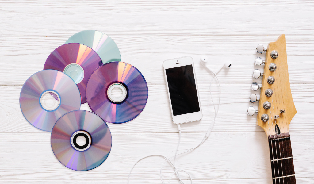 Диски с телефоном и гитарой на белом фоне