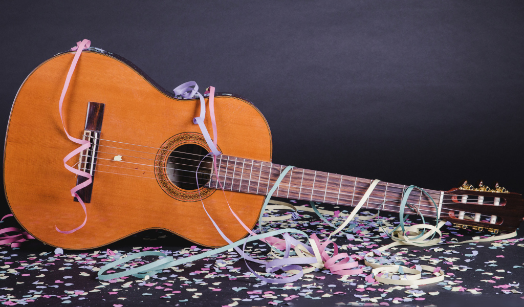 Гитара в конфетти у серой стены
