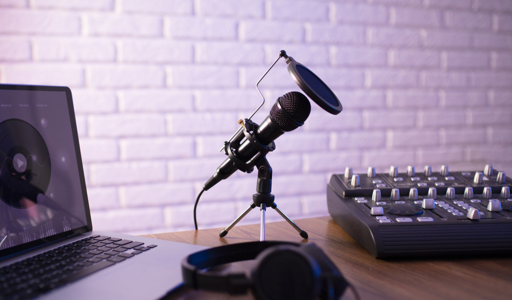 Микрофон на столе с микшером и ноутбуком