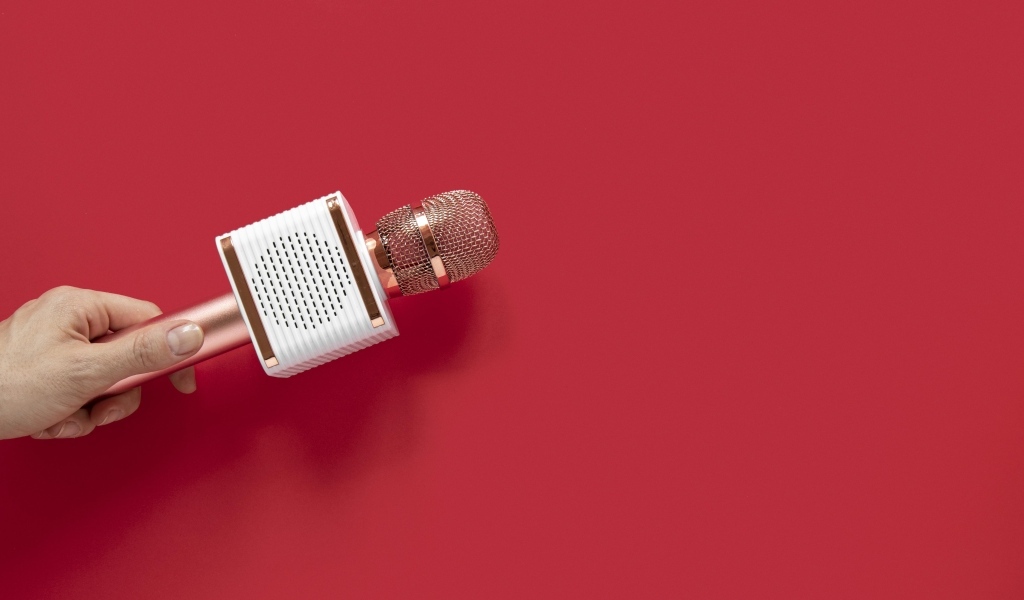 Радиомикрофон в руке на красном фоне