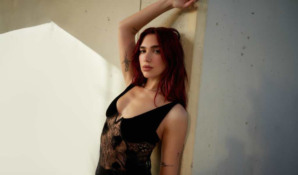 Певица Дуа Липа стоит у стены