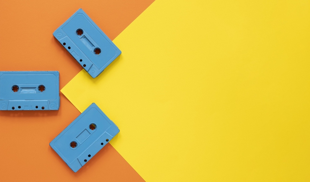 Три голубые кассеты на желто-оранжевом фоне