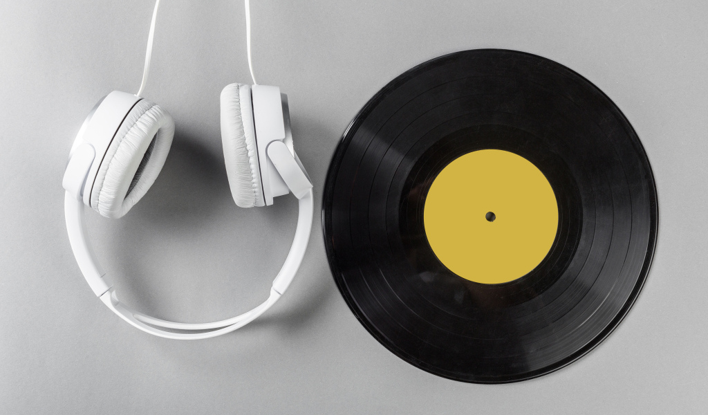 Виниловая пластинка и наушники на сером столе