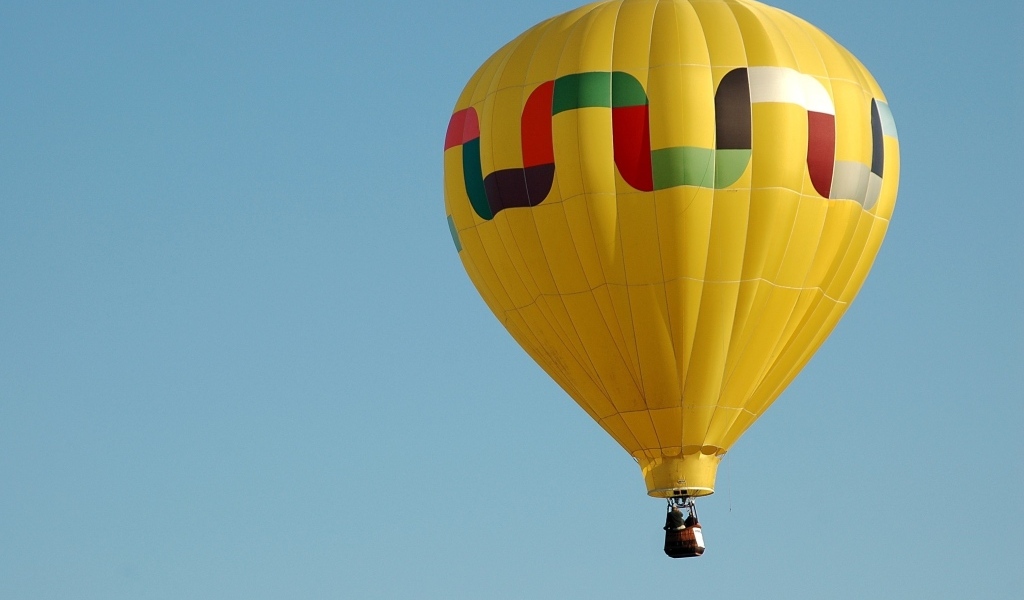 Большой желтый воздушный шар в голубом небе