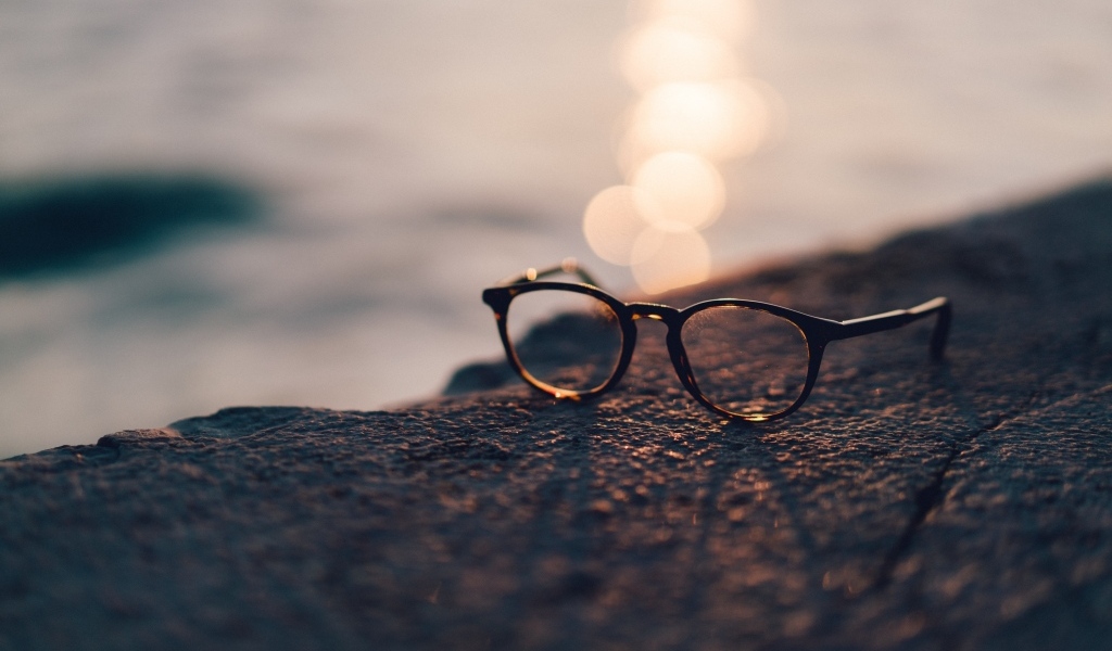 Очки лежат на камне в лучах солнца
