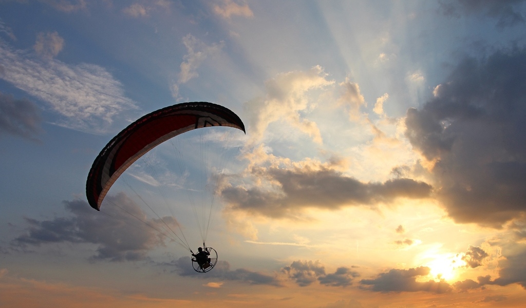 Параплан в небе на фоне солнца