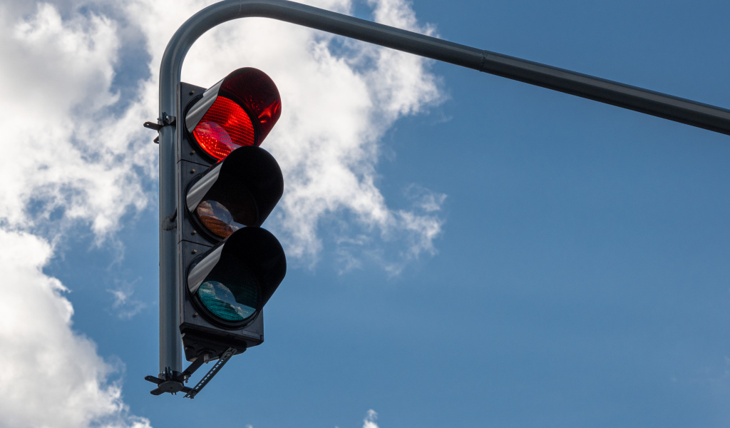 Красный свет светофора на фоне неба