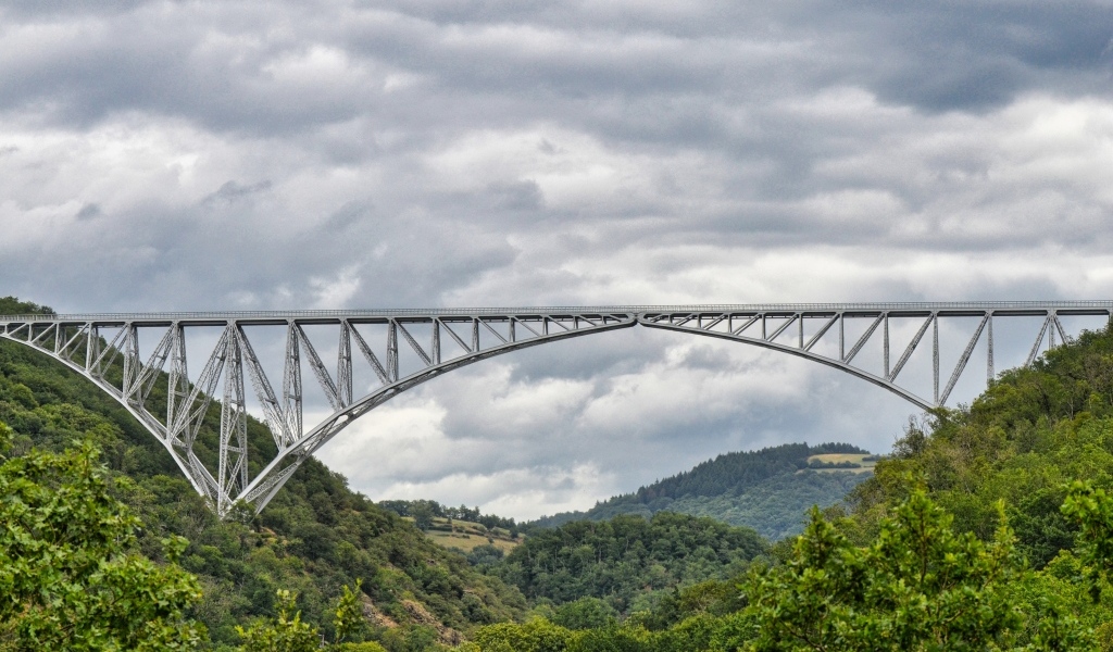Вид на стальной виадук над покрытыми зеленью горами