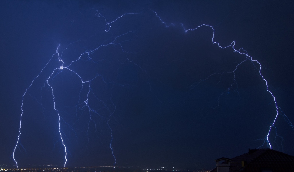 Белая яркая молния в небе над городом