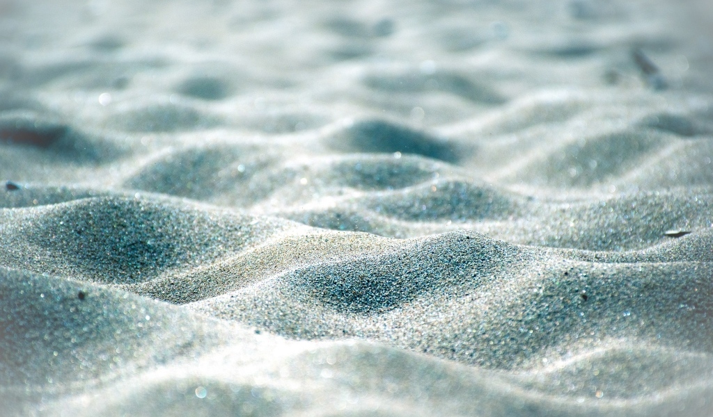 Блестящие волны песка на пляже