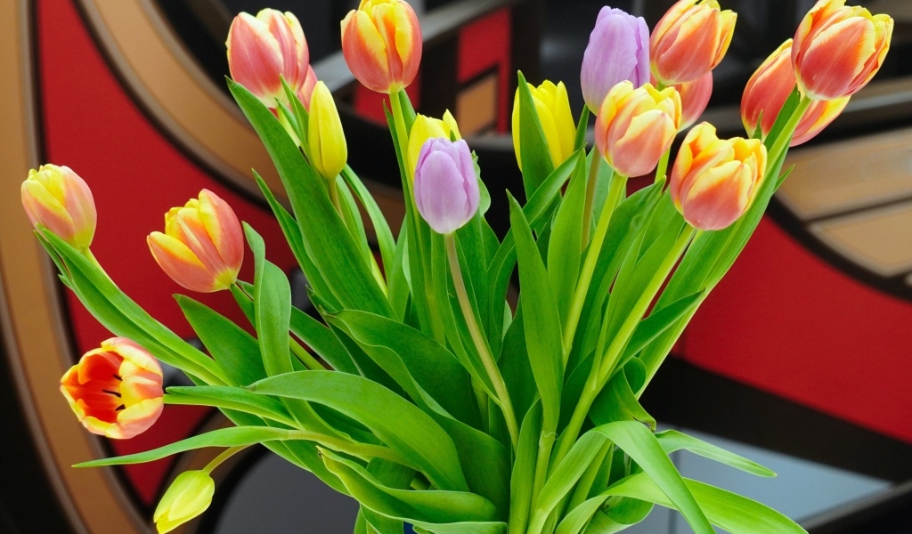 Букет красивых разноцветных тюльпанов в стеклянной вазе