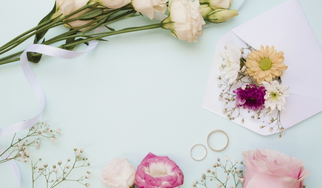 Цветы на голубом фоне с конвертом и обручальными кольцами