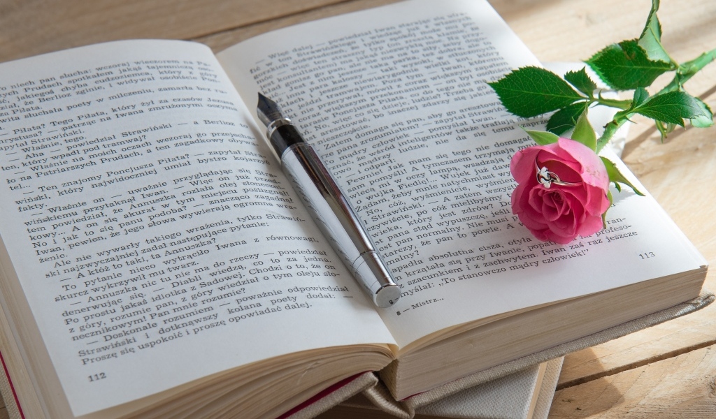 Розовая роза с кольцом на книге 