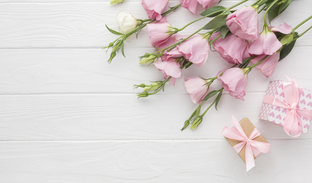 Нежна розовая эустома с подарками на белом фоне