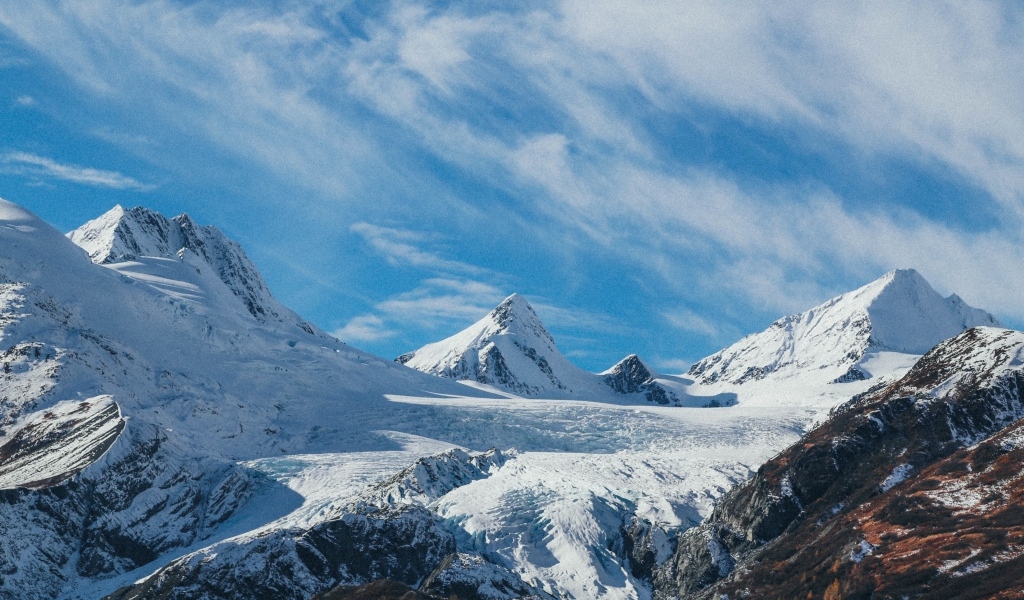 Высокие заснеженные горы под голубым ясным небом