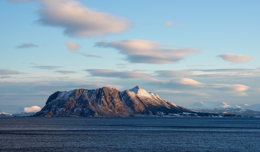Скала в лучах солнца в море