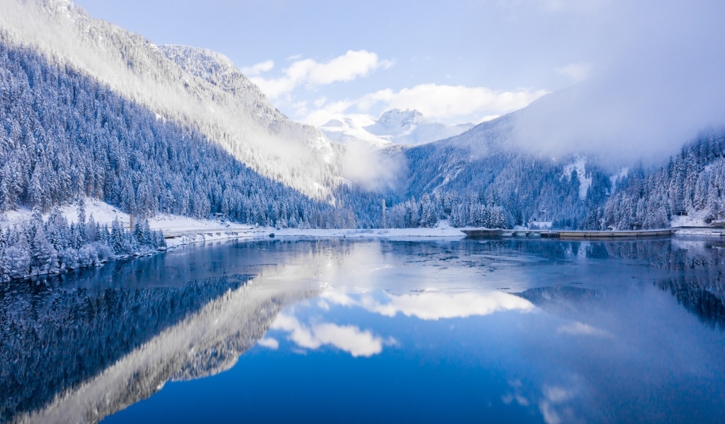 Покрытые снегом горы у покрытого льдом озера