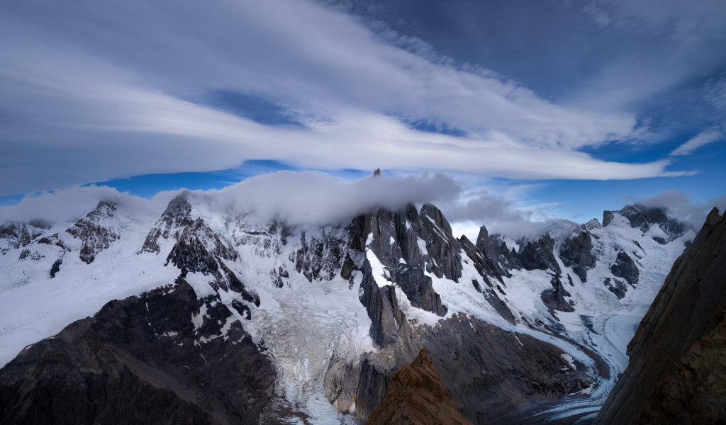 Белые облака над холодными заснеженными горами