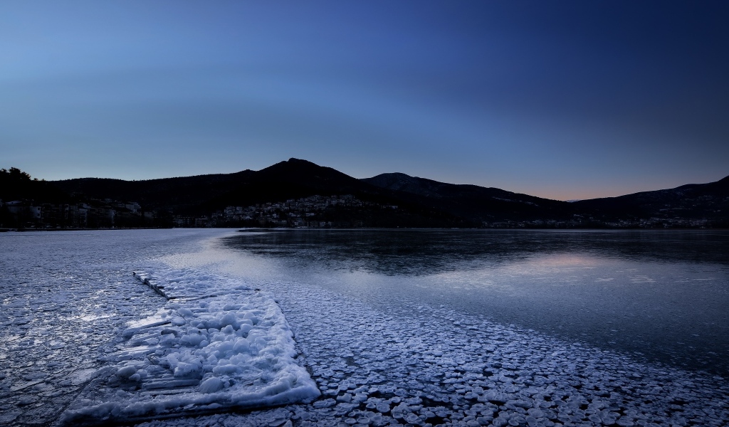 Заледеневшая вода в горном озере в сумерках