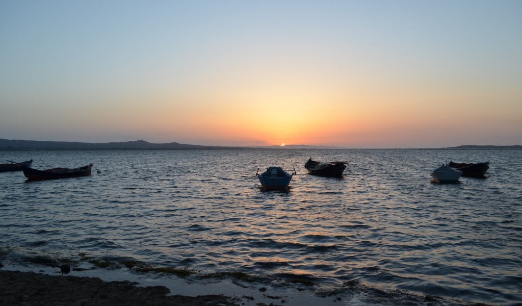 Лодки на морском побережье на закате