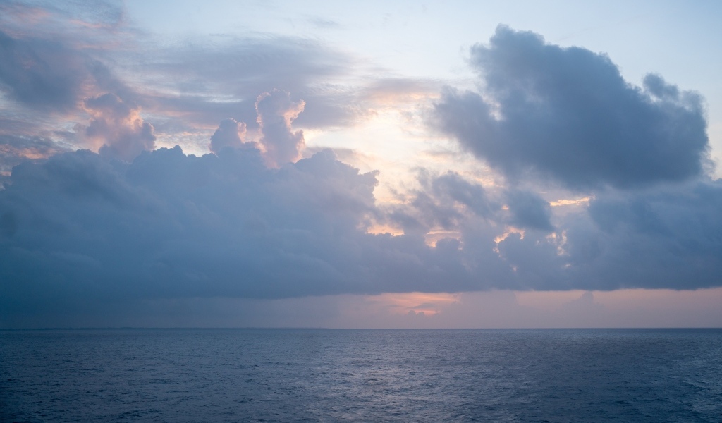 Густые белые облака над морем на рассвете летом