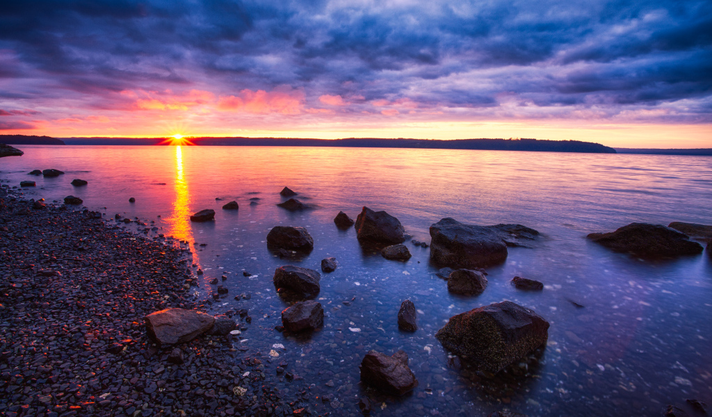 Закат солнца в пасмурном небе у озера
