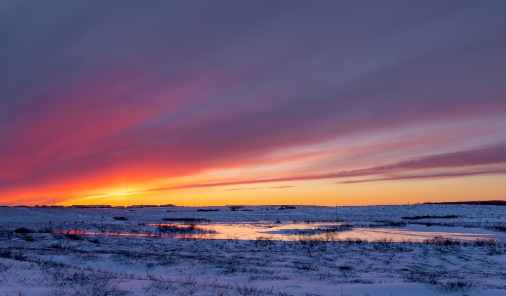 Закат солнца над покрытым снегом полем Аляски