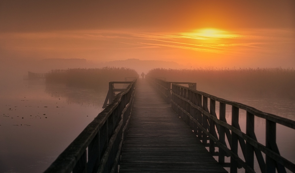 Деревянный мост над рекой на закате