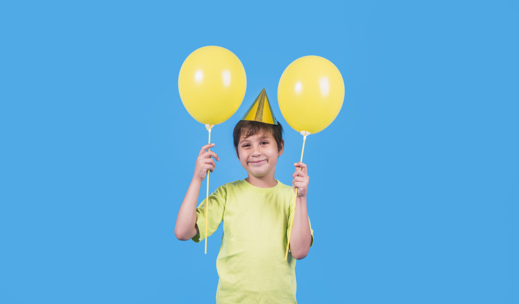 Мальчик на день рождения с желтыми шариками