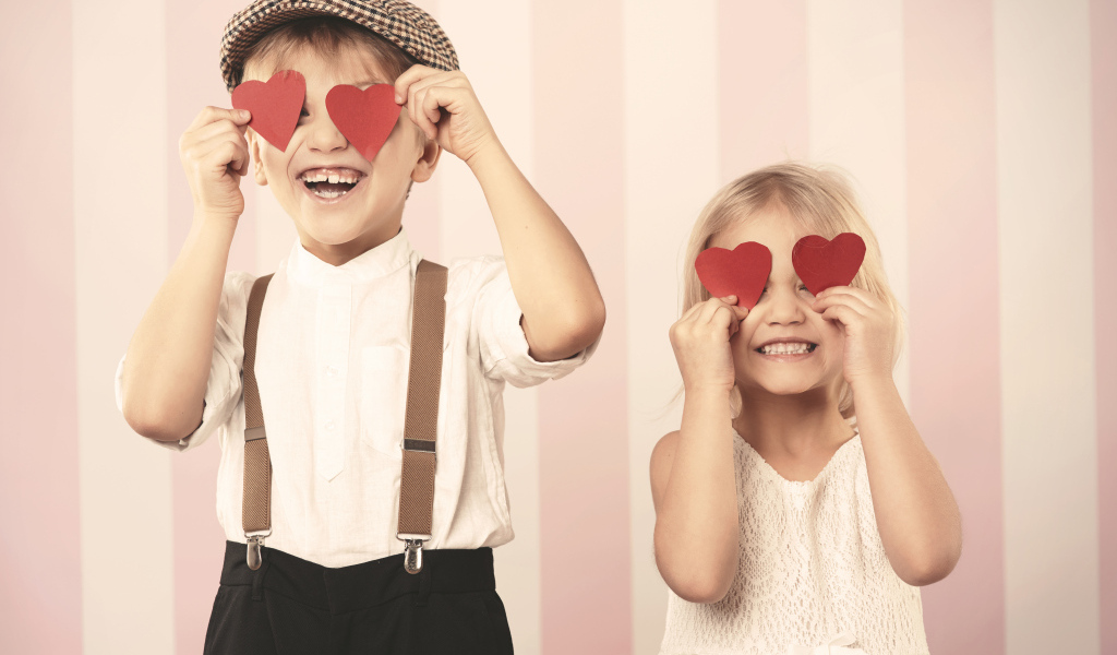 Мальчик и девочка с сердечками в руках