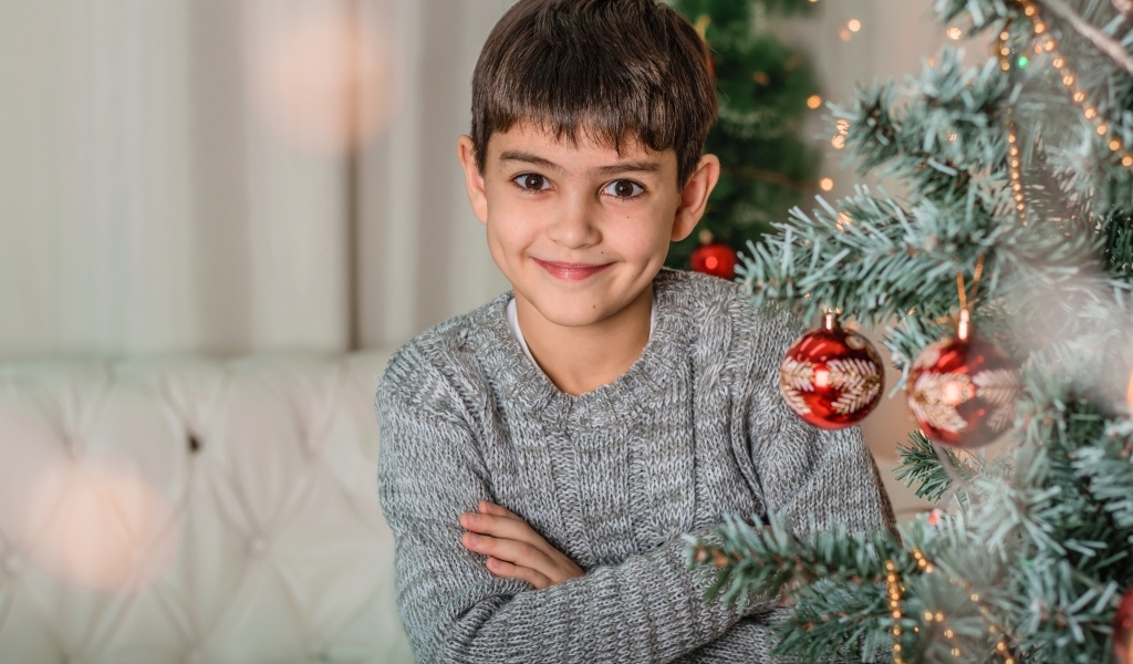 Кареглазый мальчик у новогодней ели