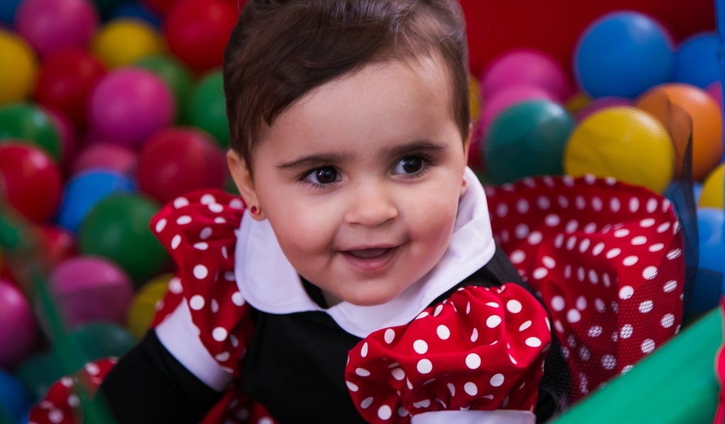 Кареглазая девочка в бассейне с шариками