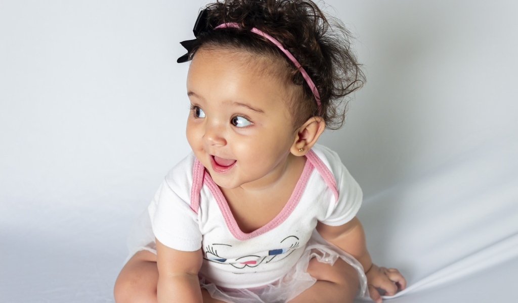 Веселая маленькая девочка с ободком на голове