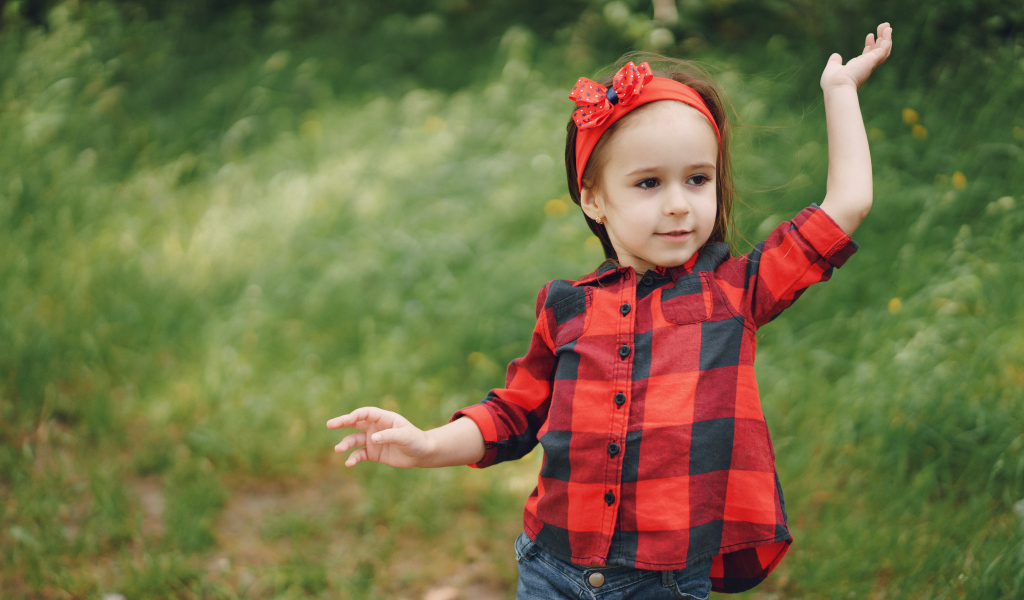 Милая девочка с красным бантом на голове 