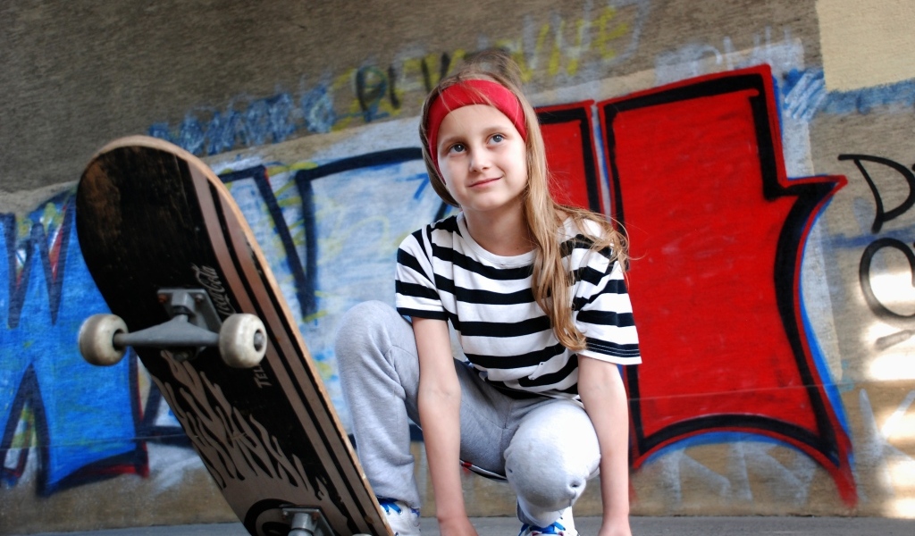 Милая маленькая девочка со скейтбордом